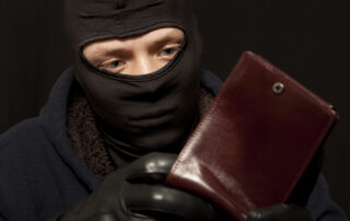 a thief sealing from a brown leather purse