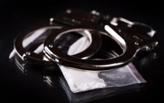handcuffs-and-cocaine-on-black-background-min